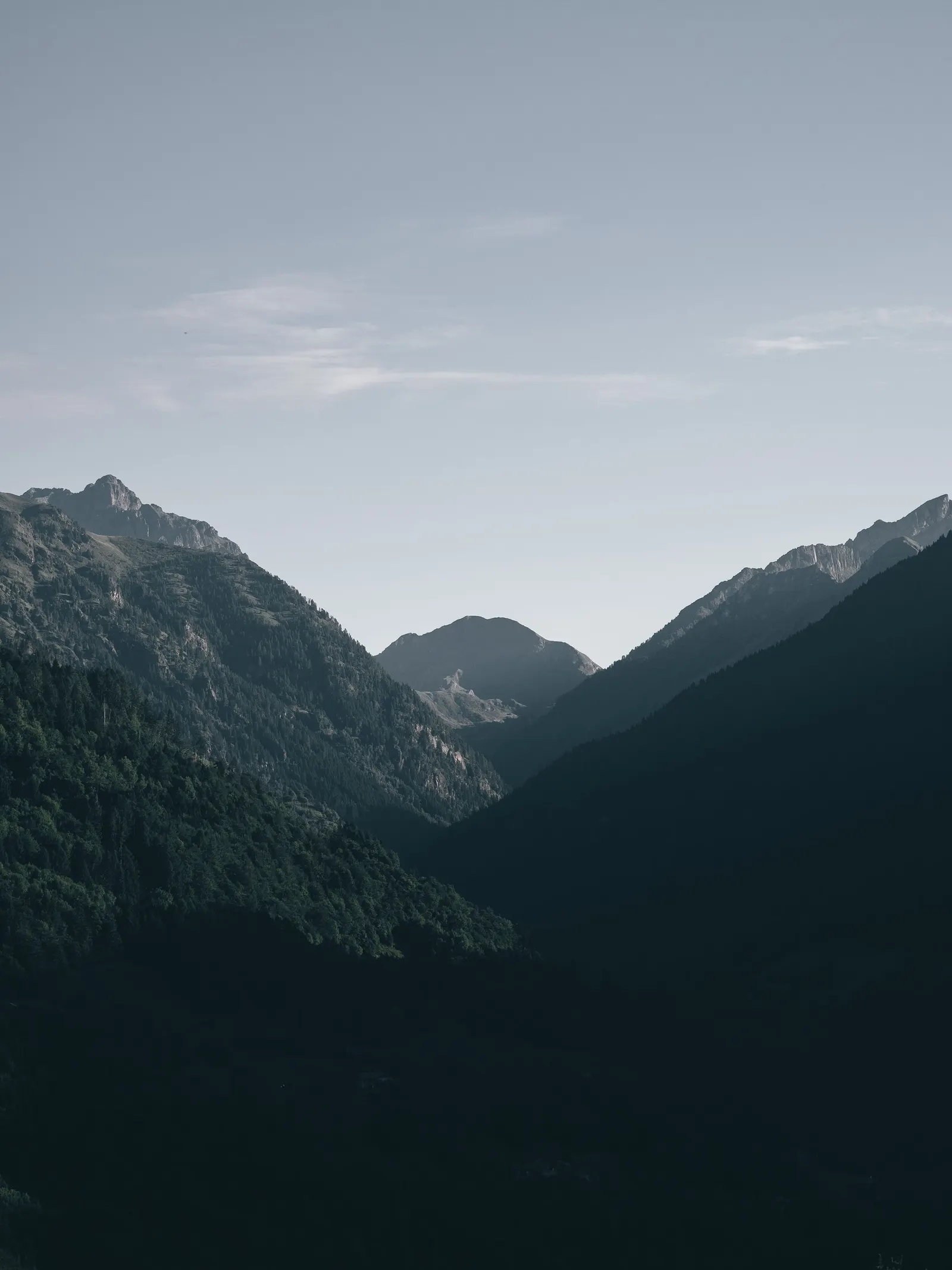 Layered mountain ridges under a clear blue sky