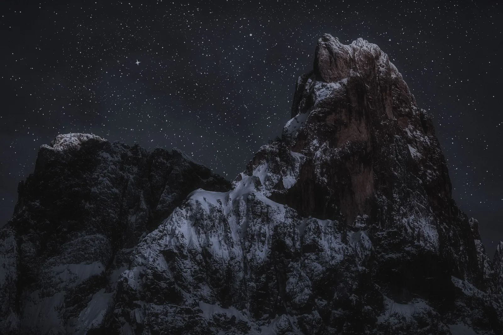 A snow-capped peak under a starry night sky