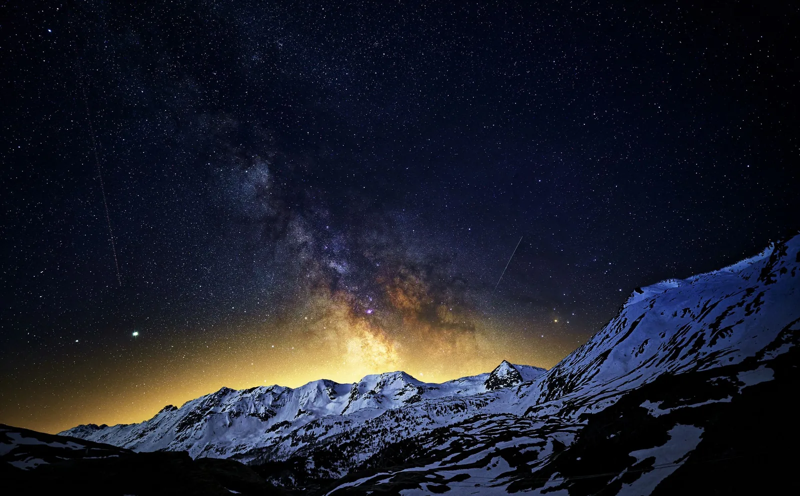 The Milky Way above a snowy mountain range